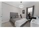 Cozy bedroom with gray walls, modern lighting, a comfortable bed, and a study area at 8935 Sonoma Coast Dr, Winter Garden, FL 34787
