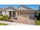 Charming home exterior featuring a brick driveway, a front porch, and a two-car garage at 8935 Sonoma Coast Dr, Winter Garden, FL 34787