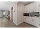 Well-lit kitchen with wood-look flooring, white cabinets, countertop appliances, and a stylish backsplash at 8935 Sonoma Coast Dr, Winter Garden, FL 34787
