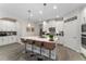 Bright kitchen featuring a large island, modern appliances, white cabinets, and barstool seating at 8935 Sonoma Coast Dr, Winter Garden, FL 34787