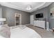 Comfortable main bedroom showcasing neutral tones, a large window and a white dresser with mounted TV at 8935 Sonoma Coast Dr, Winter Garden, FL 34787