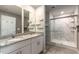Bathroom featuring double vanity sinks, granite countertops, and a stand-up glass enclosed shower with a marble surround at 1024 Desert Candle Dr, Ocoee, FL 34761