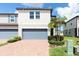 Charming townhouse showcasing a brick driveway and a serene front yard with lush landscaping and a two car garage at 1024 Desert Candle Dr, Ocoee, FL 34761
