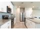 Sleek kitchen with stainless steel appliances, granite countertops, white cabinetry and tiled floors at 1024 Desert Candle Dr, Ocoee, FL 34761