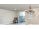 Bright living area with large windows, modern chandelier, tile floors and a comfortable sitting chair at 1024 Desert Candle Dr, Ocoee, FL 34761