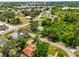 An aerial view showing houses and roads in a tree-filled area with the water tower in the background at 105 N Florida Ave, Howey In The Hills, FL 34737