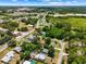 Wide aerial view showing the home in a neighborhood with a mix of houses, businesses, and surrounding greenery at 105 N Florida Ave, Howey In The Hills, FL 34737