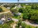 The aerial view displays the home surrounded by lush greenery, adjacent to roads, and near other residential buildings at 105 N Florida Ave, Howey In The Hills, FL 34737