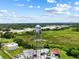 Wide aerial view of a water tower and industrial buildings on the horizon at 105 N Florida Ave, Howey In The Hills, FL 34737