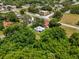 Aerial view of the property, displaying its location within a verdant neighborhood with nearby streets and houses at 105 N Florida Ave, Howey In The Hills, FL 34737