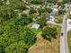 Aerial view shows the home nestled among trees, near a road, and in proximity to other houses in a suburban area at 105 N Florida Ave, Howey In The Hills, FL 34737