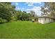 Lush, well-maintained backyard with green grass, bordered by trees, providing a serene outdoor space for relaxation at 105 N Florida Ave, Howey In The Hills, FL 34737