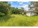 Expansive backyard surrounded by trees, offering privacy and space for outdoor activities and potential landscaping at 105 N Florida Ave, Howey In The Hills, FL 34737