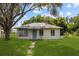 Charming single-story home with a well-maintained lawn and mature trees at 105 N Florida Ave, Howey In The Hills, FL 34737