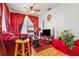 Cozy living room with bright red curtains, ceiling fan and ample natural light at 105 N Florida Ave, Howey In The Hills, FL 34737