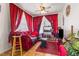 Cozy living room with bright red curtains, ceiling fan and ample natural light at 105 N Florida Ave, Howey In The Hills, FL 34737