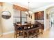 Dining room featuring a long wooden table with leather chairs, a bench, and a stylish light fixture at 1156 Castle Pines Ct, Reunion, FL 34747