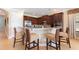 Kitchen featuring stainless steel appliances, granite countertops, dark wood cabinets, and bar seating at 1156 Castle Pines Ct, Reunion, FL 34747