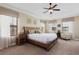 This main bedroom features a ceiling fan and a decorative headboard plus seating near large windows at 1156 Castle Pines Ct, Reunion, FL 34747