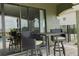 Covered outdoor patio with wicker chairs and a table, ideal for relaxing and enjoying the outdoor view at 1156 Castle Pines Ct, Reunion, FL 34747