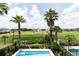 This backyard features a pool and landscaping with a view of the golf course and other homes at 1156 Castle Pines Ct, Reunion, FL 34747