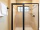 This modern shower features a glass door and tiled walls and trim plus a window for light at 1156 Castle Pines Ct, Reunion, FL 34747