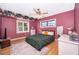 Well-lit bedroom featuring pink walls, wood flooring, a floral accent, and a ceiling fan at 1301 Fahnstock St, Eustis, FL 32726