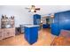 This kitchen features bright blue cabinets, stainless steel appliances, and natural wood flooring at 1301 Fahnstock St, Eustis, FL 32726