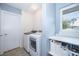 Well-lit laundry room with modern washer and dryer, storage shelf and window providing natural light at 1301 Fahnstock St, Eustis, FL 32726