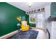 Cozy living room featuring a green accent wall, bright yellow chair, and stylish decor at 1301 Fahnstock St, Eustis, FL 32726