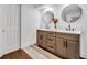 Bathroom with dual sinks, dark wood cabinets, and white countertop with white door nearby at 137 N Spring Lake Dr, Altamonte Springs, FL 32714
