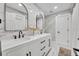 Bathroom with marble-look tile, dual sinks, modern fixtures, and white cabinets and countertops at 137 N Spring Lake Dr, Altamonte Springs, FL 32714