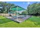 Community playground shaded by a green awning with swings and a slide over a gravel surface at 137 N Spring Lake Dr, Altamonte Springs, FL 32714