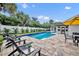 Backyard pool and patio area with mature tropical landscaping and an awning-covered outdoor dining area at 137 N Spring Lake Dr, Altamonte Springs, FL 32714