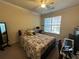 Comfortable bedroom featuring a floral comforter, bright window, and ceiling fan at 1370 Tuscan Ter # 2202, Davenport, FL 33896