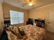 Comfortable bedroom featuring a floral comforter, bright window, and ceiling fan at 1370 Tuscan Ter # 2202, Davenport, FL 33896