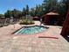 Community hot tub area with nearby sun umbrellas, lounge chairs, and lush landscaping at 1370 Tuscan Ter # 2202, Davenport, FL 33896
