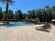 Community pool area with sun loungers and palm trees at 1370 Tuscan Ter # 2202, Davenport, FL 33896