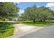 Long driveway leading to a house with a lush, green lawn and mature trees at 14128 Bramble Bush Ct, Orlando, FL 32832