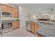 Modern kitchen with granite countertops, stainless steel appliances, and a view into the living area at 14128 Bramble Bush Ct, Orlando, FL 32832