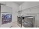 A well-equipped laundry room featuring a washer, dryer, mini-fridge, and ample storage space at 14128 Bramble Bush Ct, Orlando, FL 32832