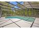 Screened pool surrounded by lush greenery and a spacious pool deck at 14128 Bramble Bush Ct, Orlando, FL 32832