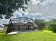 Beautiful backyard features a screened-in pool and lush green lawn; perfect for relaxation and outdoor fun at 14700 Chadbury Ct, Orlando, FL 32828