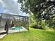 Lush, green backyard with a screened-in pool; providing a private outdoor space and serene nature views at 14700 Chadbury Ct, Orlando, FL 32828