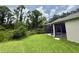 Beautiful backyard features a screened-in lanai, lush lawn, and wooded surroundings at 14700 Chadbury Ct, Orlando, FL 32828