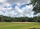 Community baseball field, featuring a well-kept field, and tree lined borders under a bright blue sky at 14700 Chadbury Ct, Orlando, FL 32828