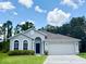 Beautiful single-story home with manicured lawn, arched windows, and two-car garage at 14700 Chadbury Ct, Orlando, FL 32828