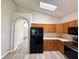 Open-concept kitchen featuring a black refrigerator and wooden cabinets at 14700 Chadbury Ct, Orlando, FL 32828