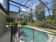 View of pool from inside the screened enclosure, with views of the home's exterior and surrounding landscape at 14700 Chadbury Ct, Orlando, FL 32828