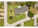 Aerial view of a home with a well-manicured lawn, mature trees, and neighborhood streets at 1505 N Lake Mirror Nw Dr, Winter Haven, FL 33881